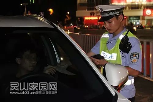 图为民警在检查驾驶员的行驶证和驾驶证