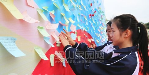 图为学生在粘贴防艾宣传卡片。 